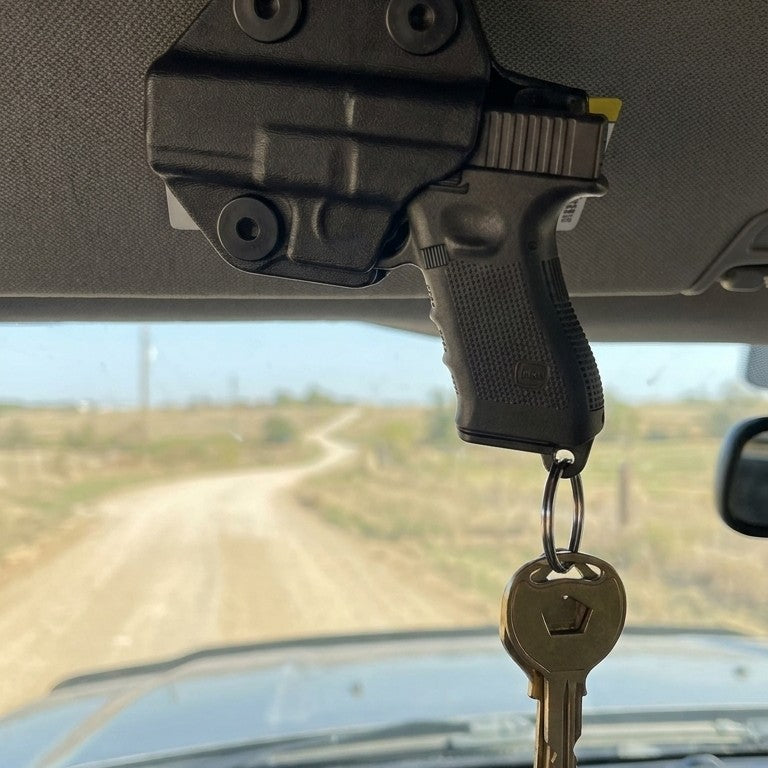 The key holster clipped to a pickup truck sun visor